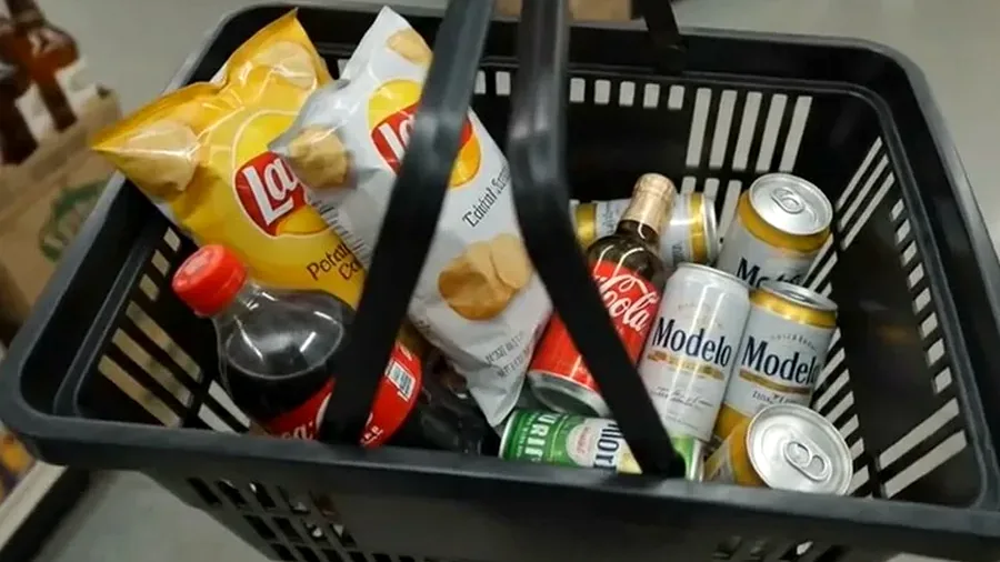 Shopping basket with drinks and snacks near checkout