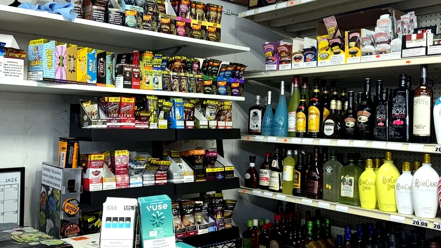 Real tobacco, wraps, vape, and accessory shelves inside Harrison Liquor