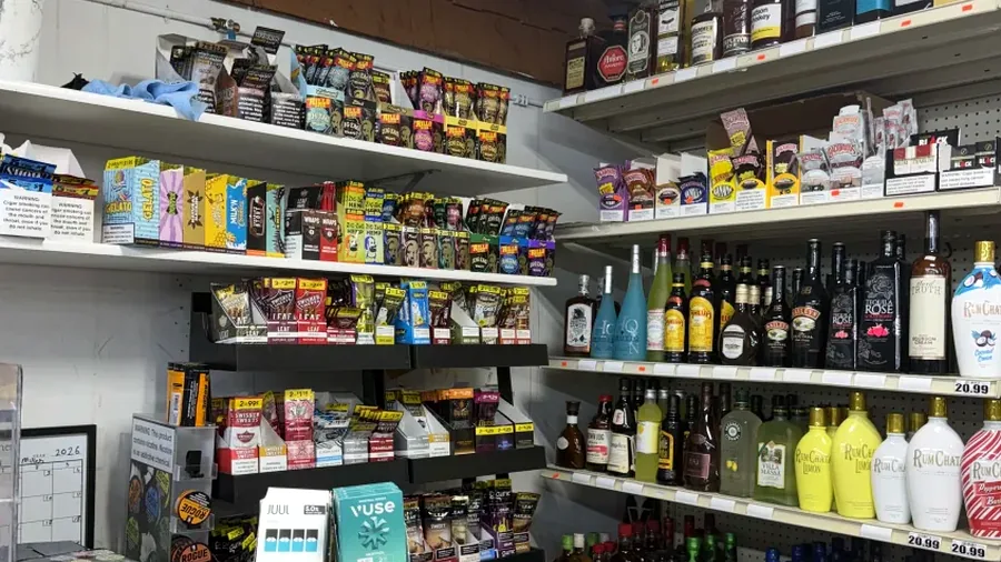 Real adult tobacco, wrap, and vape shelf view inside Harrison Liquor